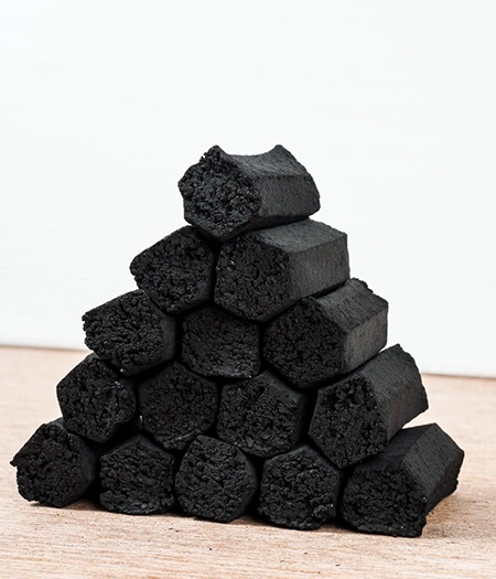 Stack of hexagonal charcoal briquettes designed for consistent heat output and eco-friendly cooking.