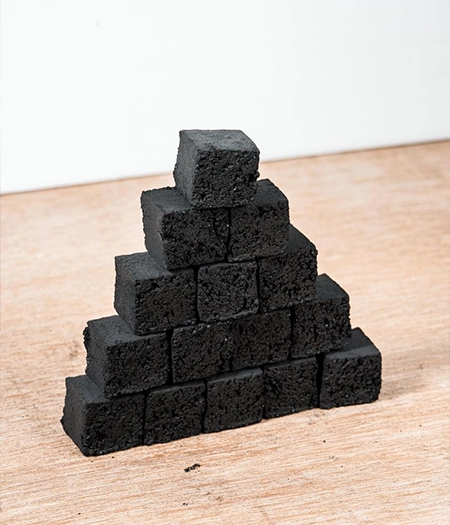 Compact cube charcoal pieces neatly stacked to highlight durability and even heat distribution for professional grilling.